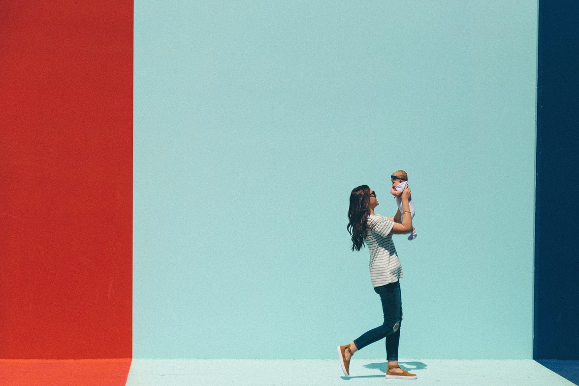 Smiling mother with newborn, emphasizing gentle healing and wellness after childbirt