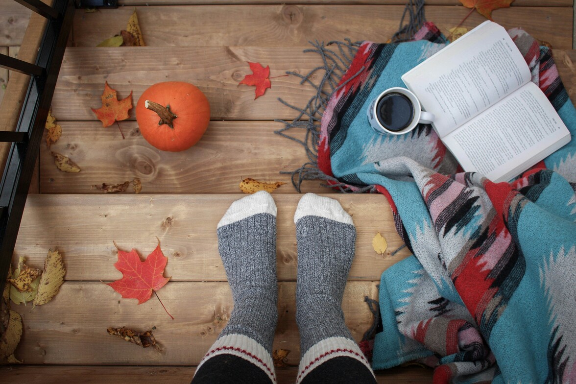 Cozy autumn scene with socks and tea, emphasizing warmth and self-care in fall.