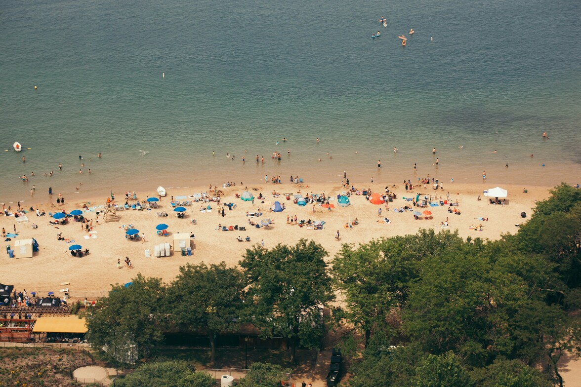 People enjoying a sunny summer day at a Chicago beach along Lake Michigan.